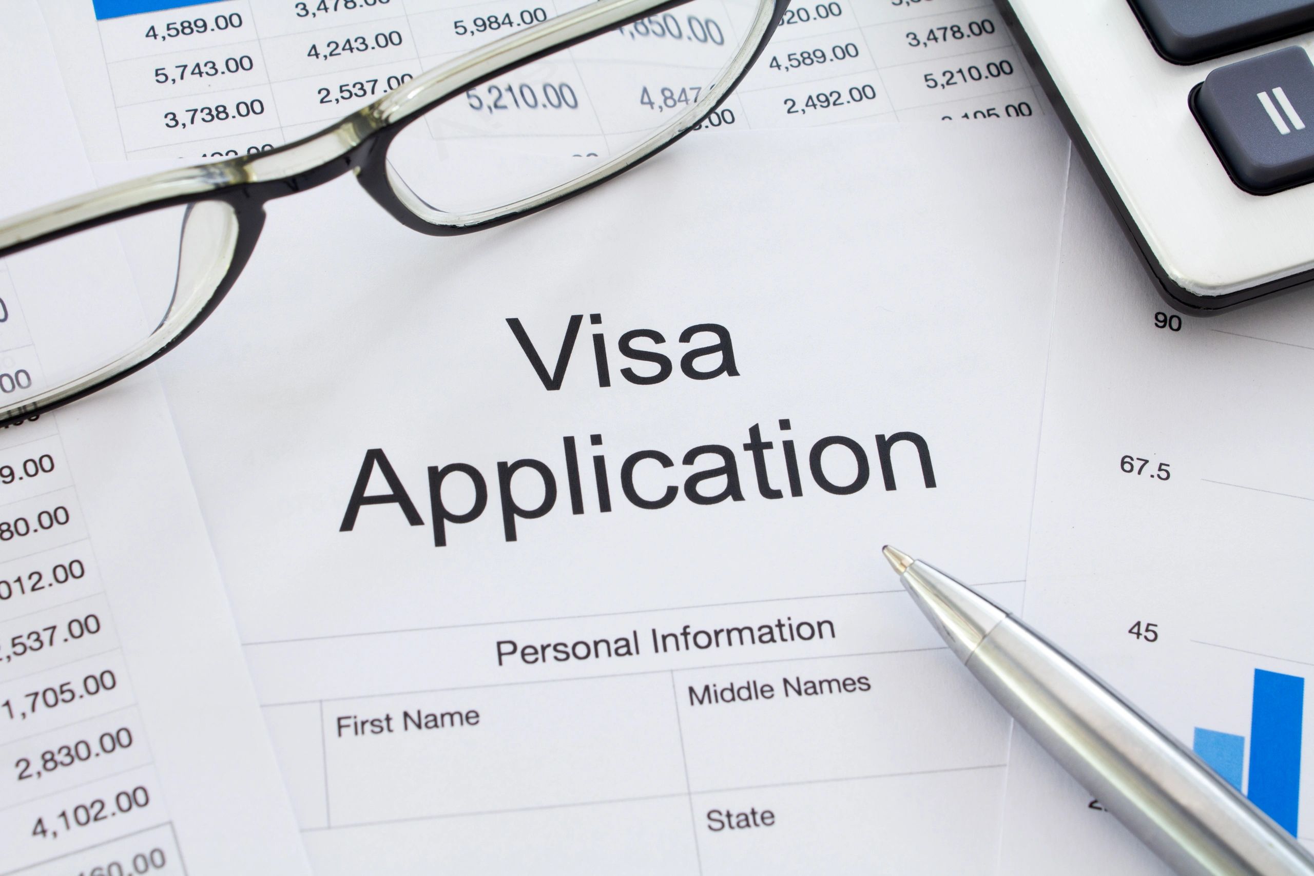Visa application form on a desk with pen and documents